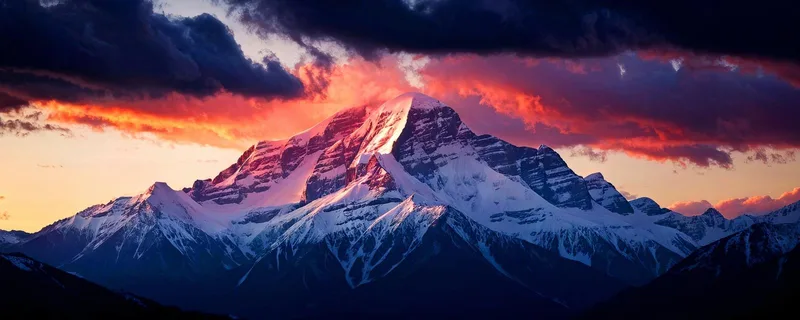 Quadro Montagne Maestosa Montagna Innevata Al Tramonto Con Cielo Drammatico